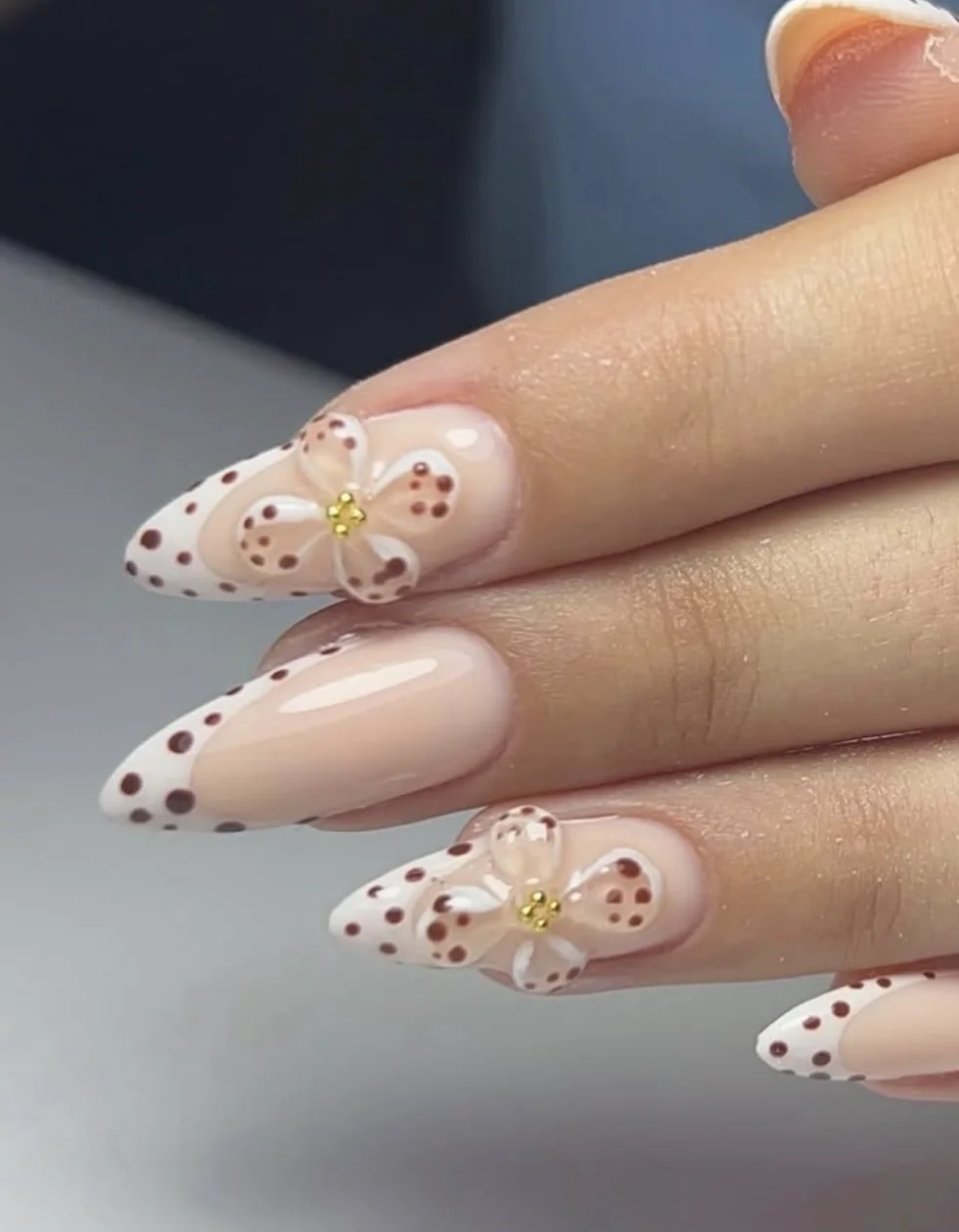 Faux ongles en manucure russe, french à pois et fleurs blanches en relief