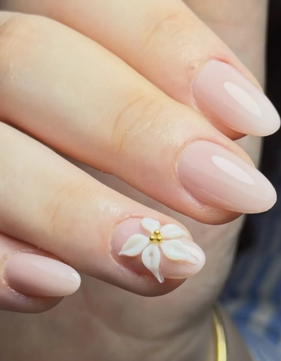 Manucure russe BIAB nude, forme amande, avec une fleur blanche en relief