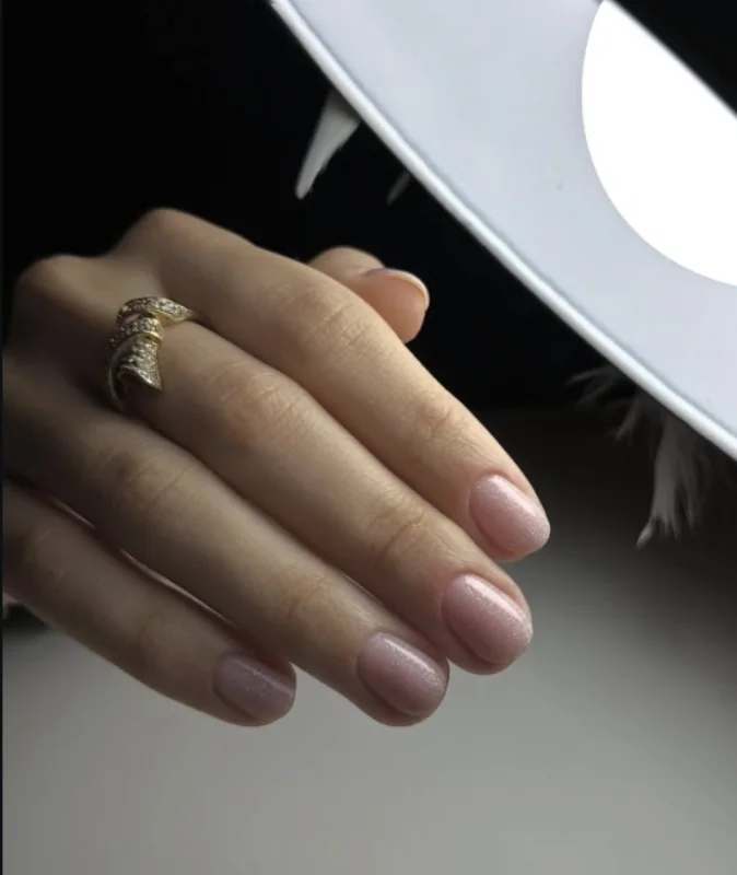Pose nude taupe sur ongles courts, portée avec une bague ciselée